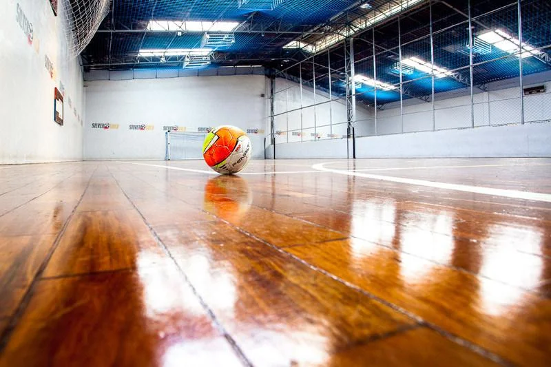 Bola de futsal sobre o piso brilhante da quadra